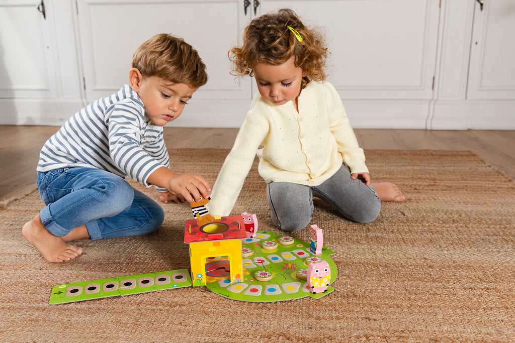 Overhead view of the Goula 3 Little Pigs board mid-game with the pigs advancing on the house
