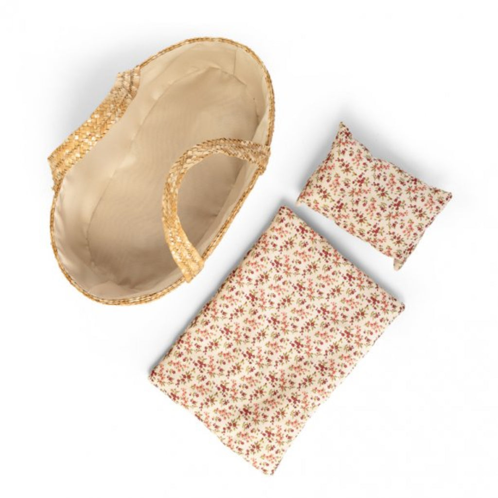 Beige moses basket for dolls with floral-patterned pouches on a white background