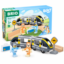 Brio Bluey Train toy set with a gray and yellow train, three colorful dog figures, a small white suitcase, and wooden tracks, shown next to its blue retail box on a white background.