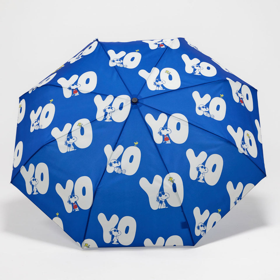Blue umbrella with white 'YO' pattern on a light gray background