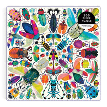 A square 500-piece jigsaw puzzle featuring a vibrant collage of colorful beetles, butterflies, and ladybugs on a white background, with a black circular badge in the top right that reads '500 PIECE PUZZLE' and the brand 'mudpuppy' printed below it.