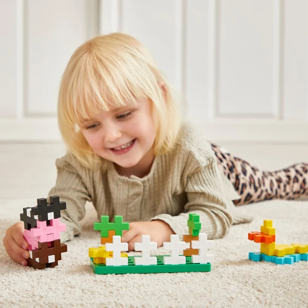 Farm animals built from oversized Plus-Plus BIG pieces standing on the green baseplate