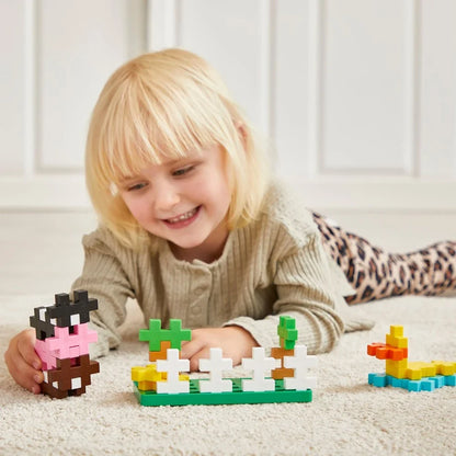 Farm animals built from oversized Plus-Plus BIG pieces standing on the green baseplate
