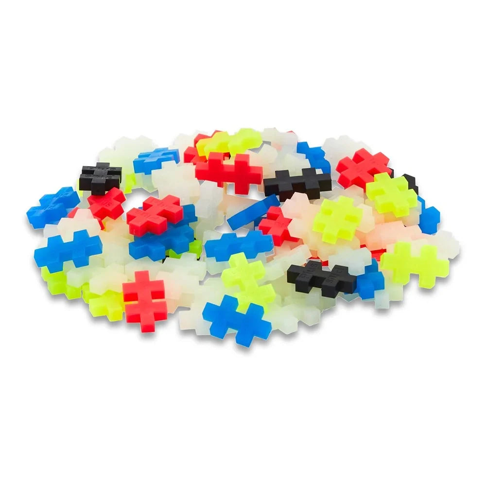 Coral, black, neon and glow Plus-Plus pieces tipped out of the 100 piece tube in daylight