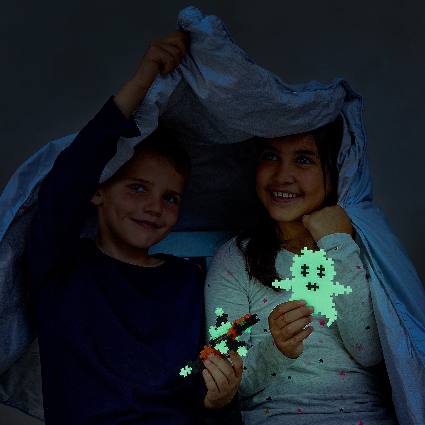 The same Plus-Plus pieces photographed in a darkened room, glowing pale green 