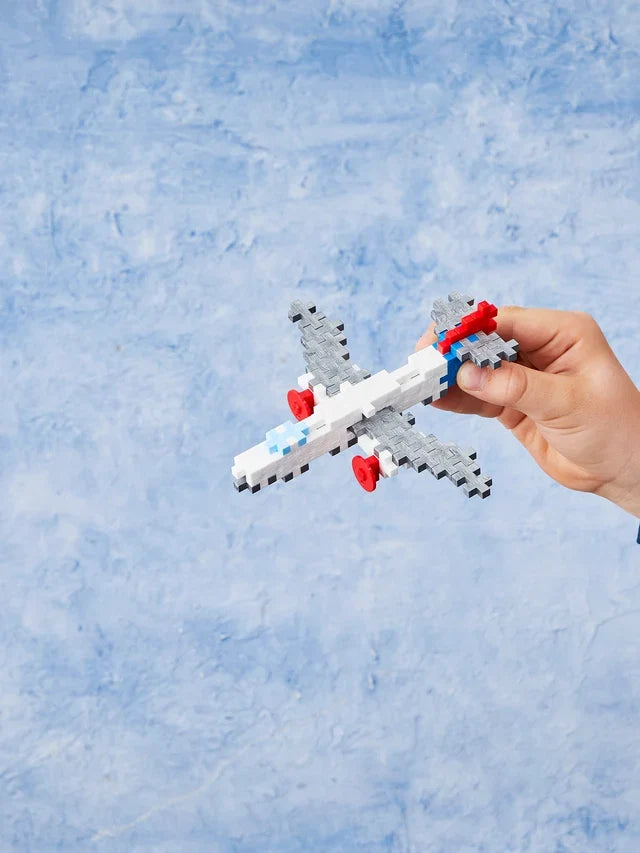 Plus-Plus Airplane 100 piece building tube standing upright against a plain white background