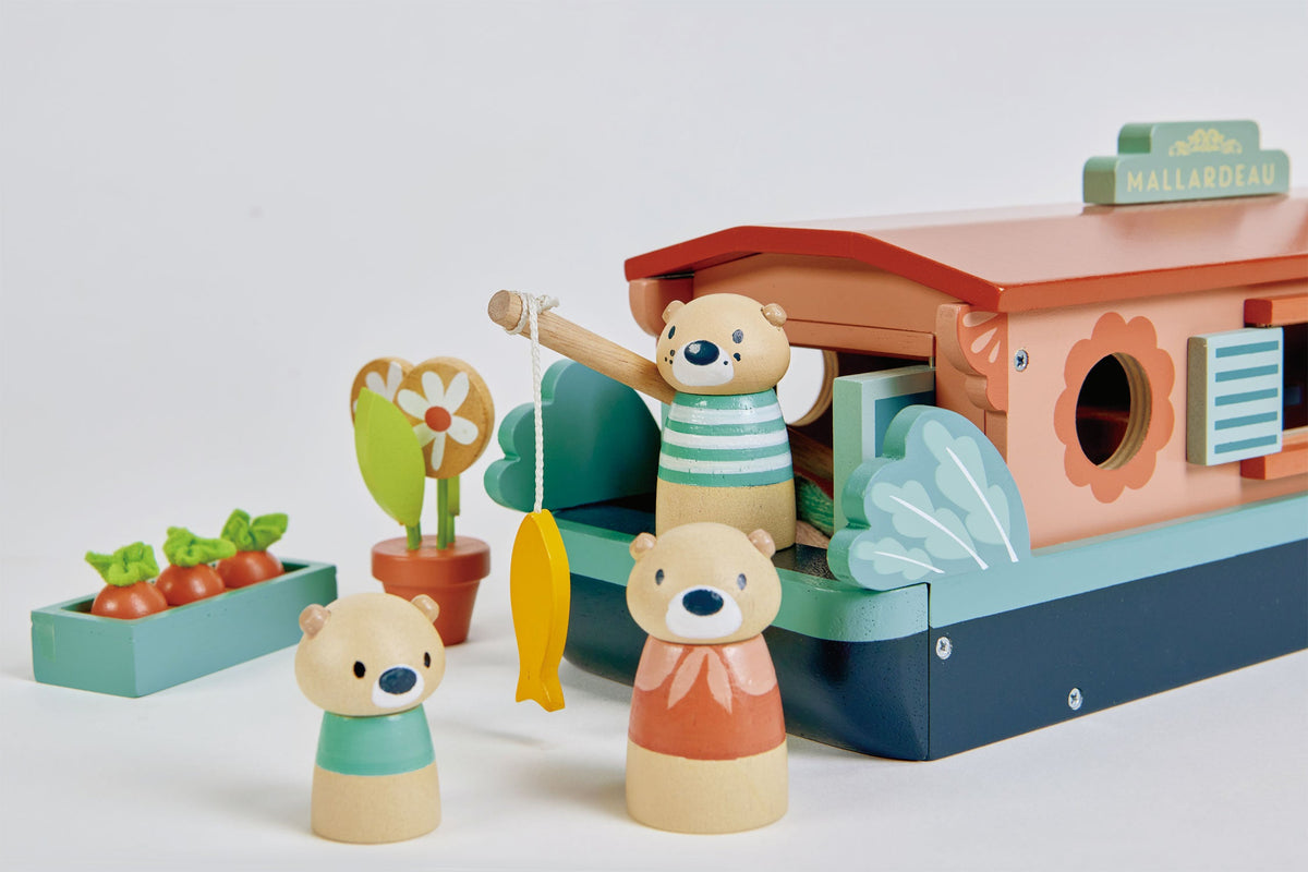 Tender Leaf Toys Little Otter Canal Boat featuring three wooden otter characters, a fishing rod with yellow fish, potted flowers, vegetable planter and decorative blue wooden boat details.
