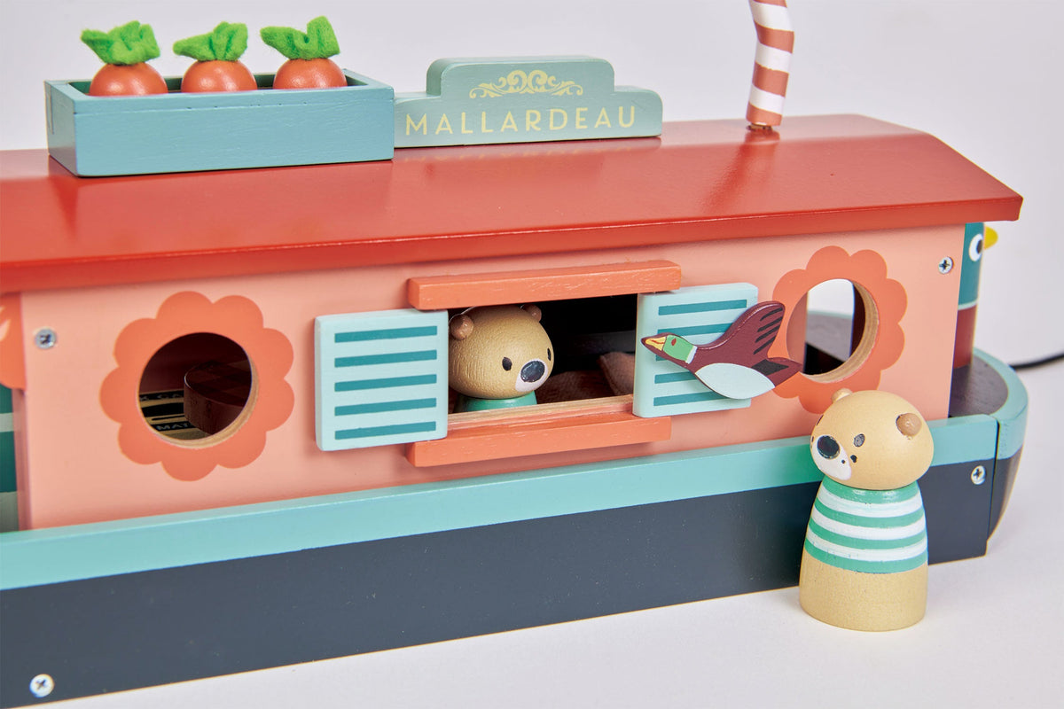 Close-up of Tender Leaf Toys Little Otter Canal Boat showing the pastel pink wooden cabin, opening blue shutters, flower-shaped windows, otter figures and decorative Mallardeau nameplate.