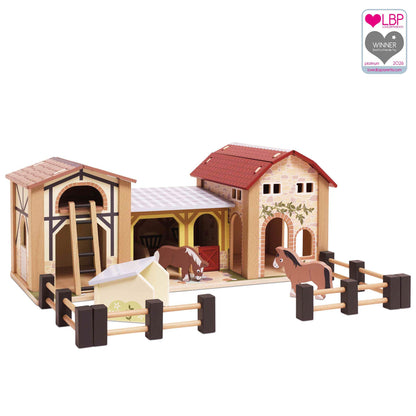 Le Toy Van Wooden Farmyard Set featuring detailed wooden barns and stables, two horses, a hay loft ladder, pigsty and movable wooden fences, with a Love by Parents 2026 award badge.