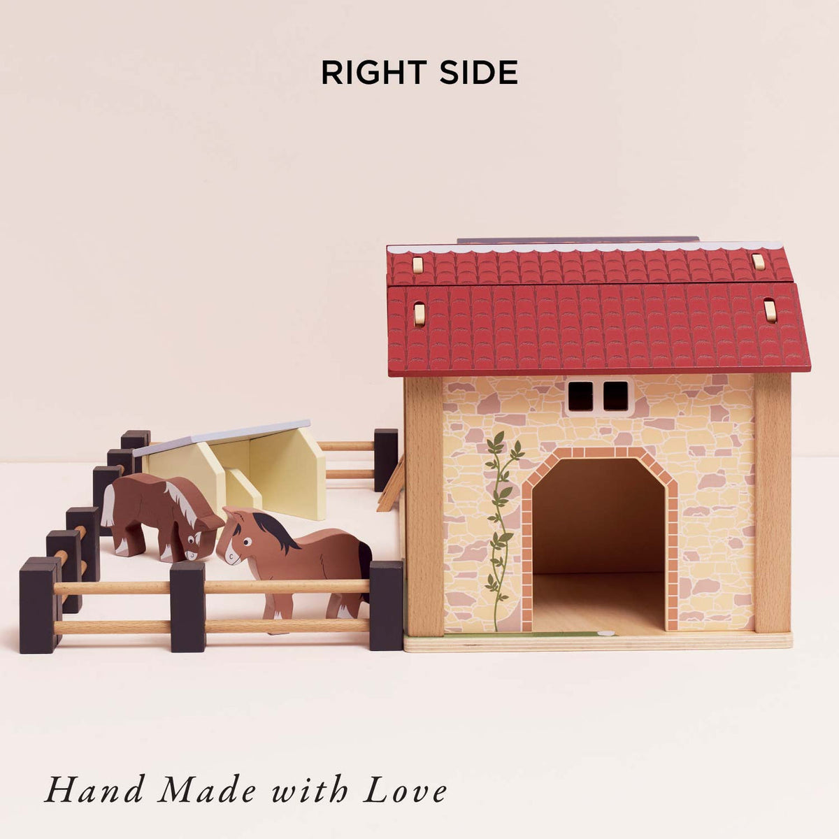 Front view of Le Toy Van Wooden Farmyard Set featuring the included pigsty, movable wooden fences, two horses, stable buildings and hay loft ladder, encouraging imaginative farm play.