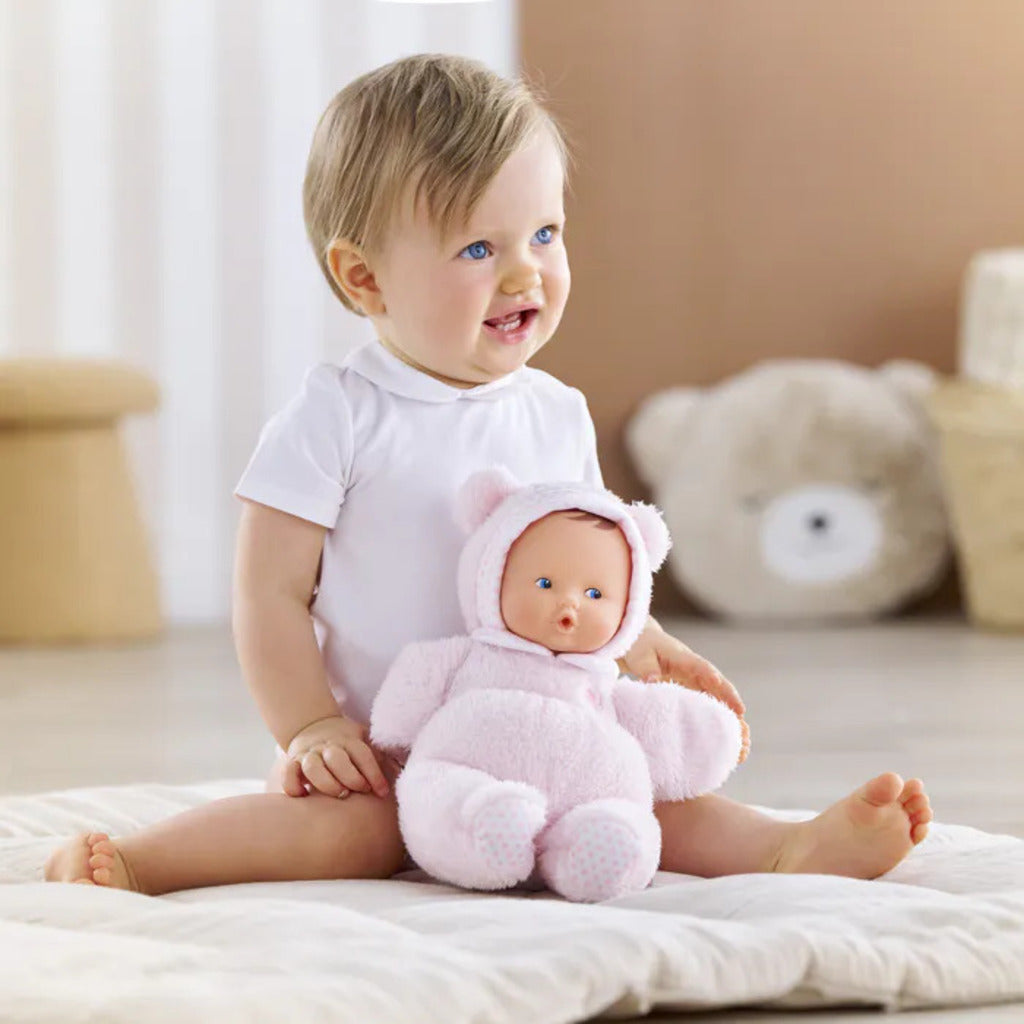Baby holding the Babibear doll by its bear-ear hood, showing how the soft grip points suit tiny hands