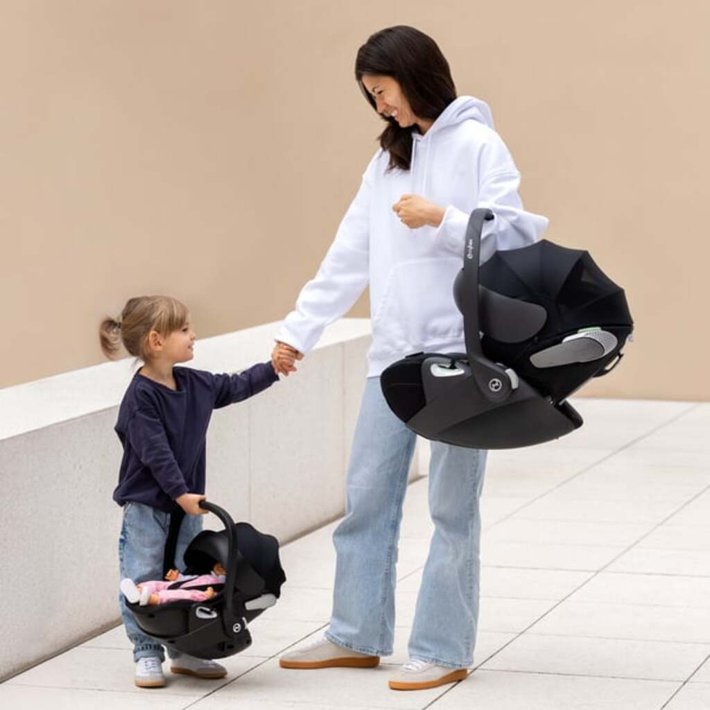 Black Cybex doll carrier shown with the matching black Corolle x Cybex 3-in-1 doll pram