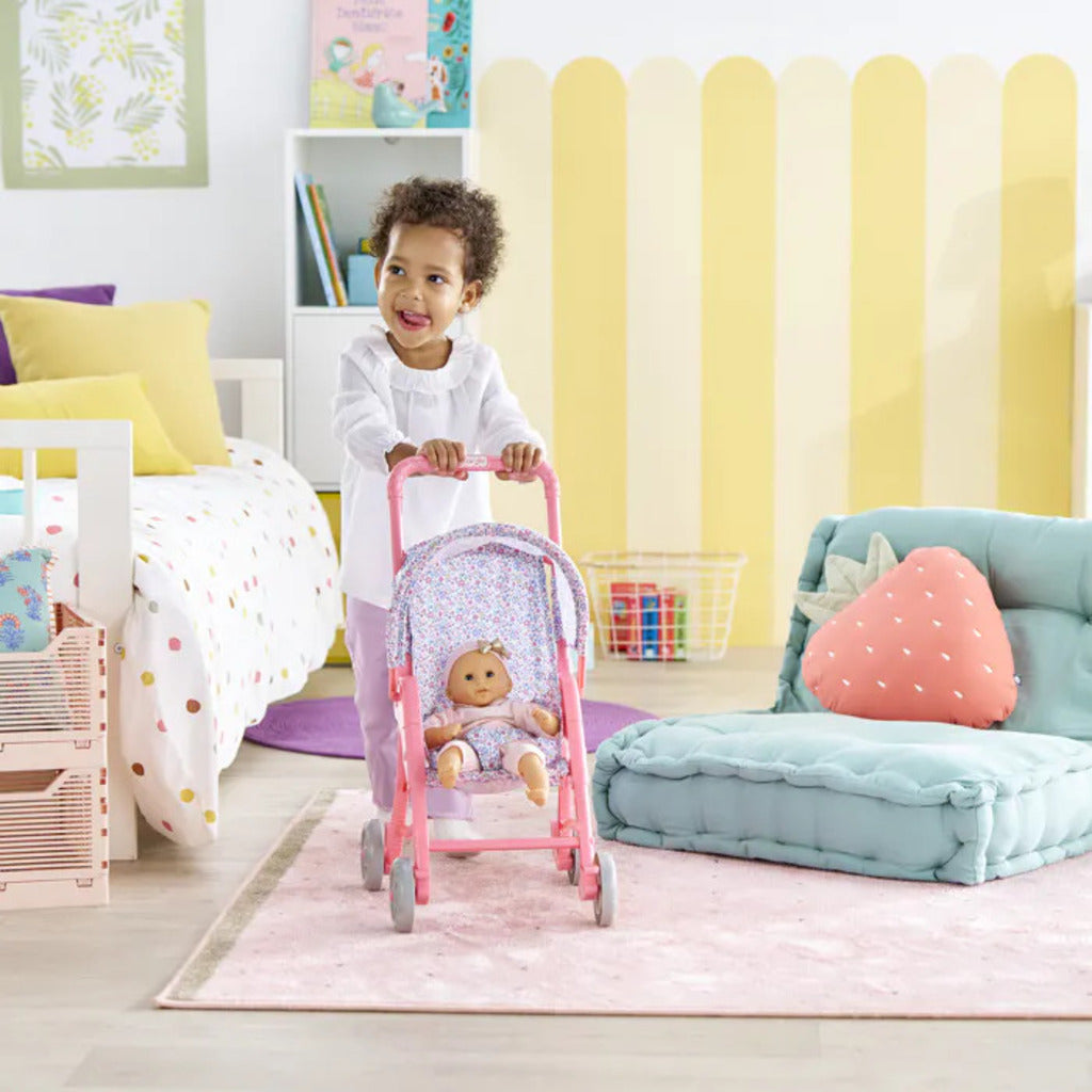 Child adjusting the canopy of the flowered doll stroller over a 30cm Corolle baby doll