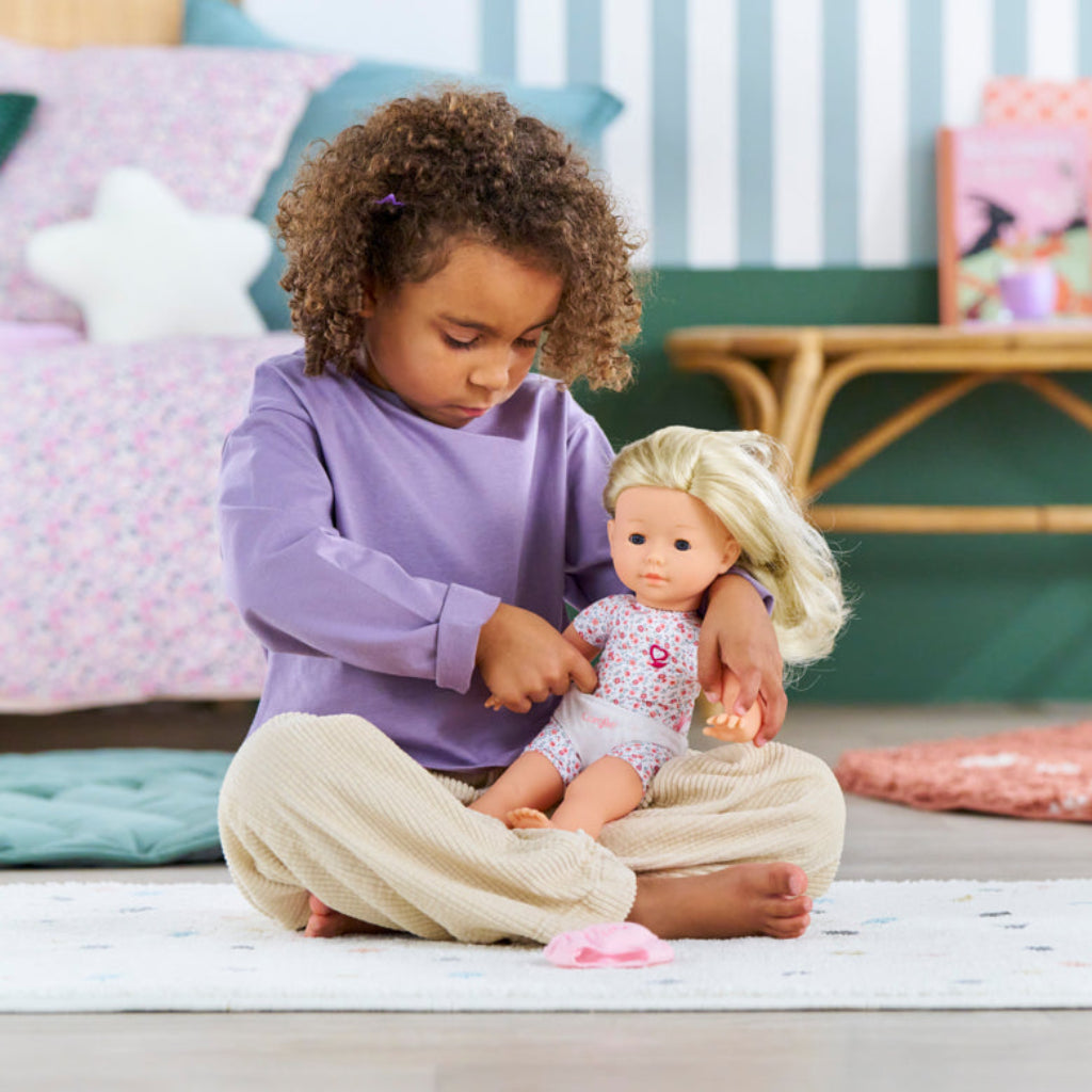 Child dressing a 36cm Ma Corolle doll wearing white briefs