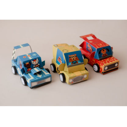 Child assembling and decorating a race car from the Djeco Do It Yourself Grand Prix craft kit at a table