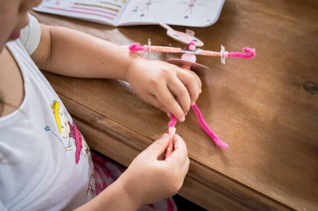 Child threading a lace through a fairy card from the Djeco My Fairies kit during quiet time