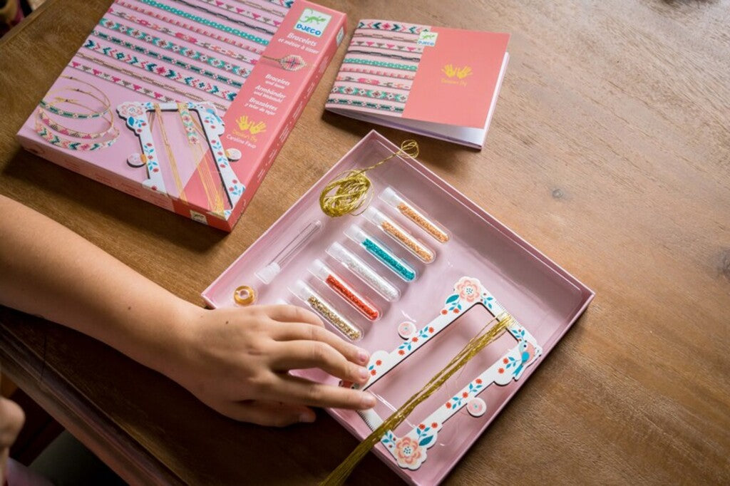 Djeco Tiny Beads bracelet set contents laid out, including beads, threads and instructions
