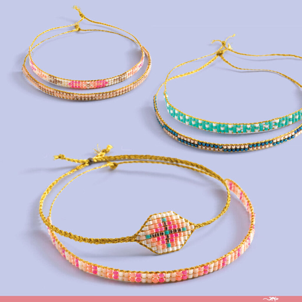 Stack of friendship bracelets made with the Djeco Tiny Beads kit, ready to share