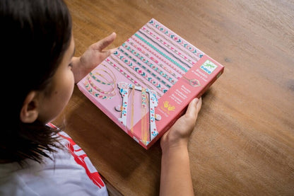 Colourful handmade bracelet from the Djeco Tiny Beads set worn on a child's wrist