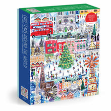 Galison Michael Storrings Christmas Around the World 1500 piece puzzle Jigsaw puzzle box with a colorful illustration of a Christmas-themed cityscape on a white background