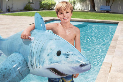 Child riding the Bestway inflatable shark pool float in a backyard swimming pool in summer