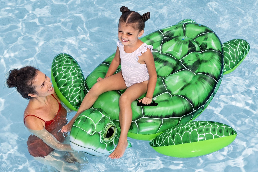 Child riding the Bestway Tidal Turtle inflatable pool float in a backyard swimming pool
