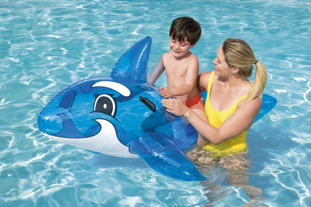 Child riding the Bestway inflatable whale pool float in a backyard swimming pool in summer