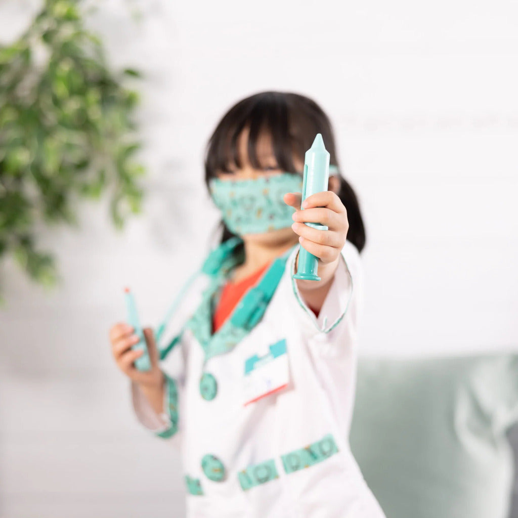 Close-up of the clear front pockets on the kids doctor coat holding toy medical tools for pretend appointments
