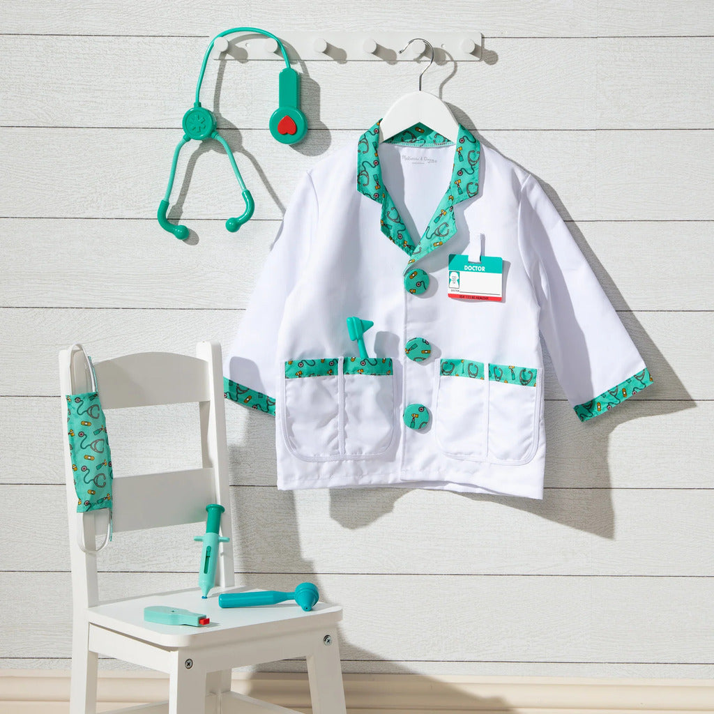 Complete kids doctor costume set laid flat with coat, mask, name tag, stethoscope and toy medical instruments