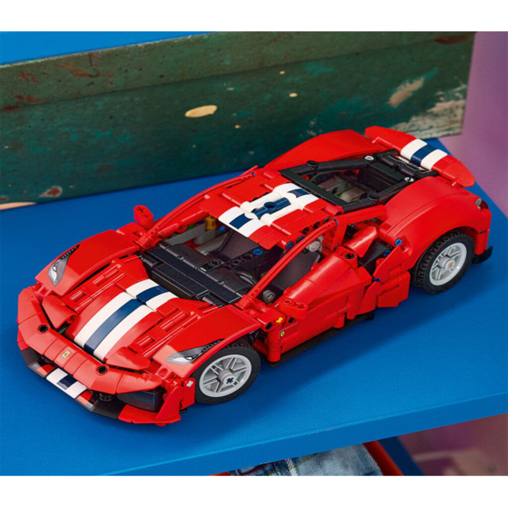 LEGO Ferrari 488 Pista displayed on a shelf in a home study next to a model car collection