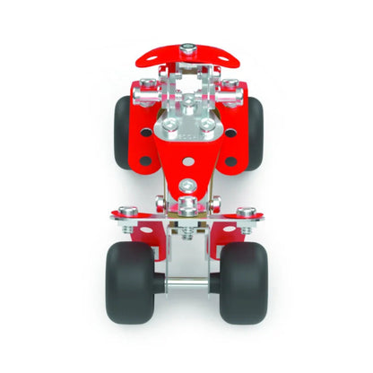 A miniature red and silver metal meccano toy vehicle chassis with four black wheels, shown from a top-down perspective on a solid white background.