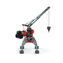 A toy construction crane built from interlocking plastic building blocks, featuring a gray and black body with red accents, a long articulated arm, and a hanging hook with cables, shown on a plain white background.
