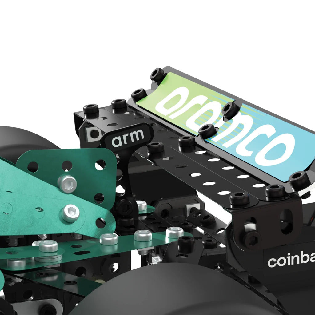 Close-up of a robotic arm assembly with black metal brackets, silver bolts, and green metal plates. A sign on the arm reads 'orion' in white text over a green-to-blue gradient background.