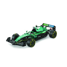 A green and black building block toy race car with bright yellow accents, shown from a three-quarters angle on a clean white background.