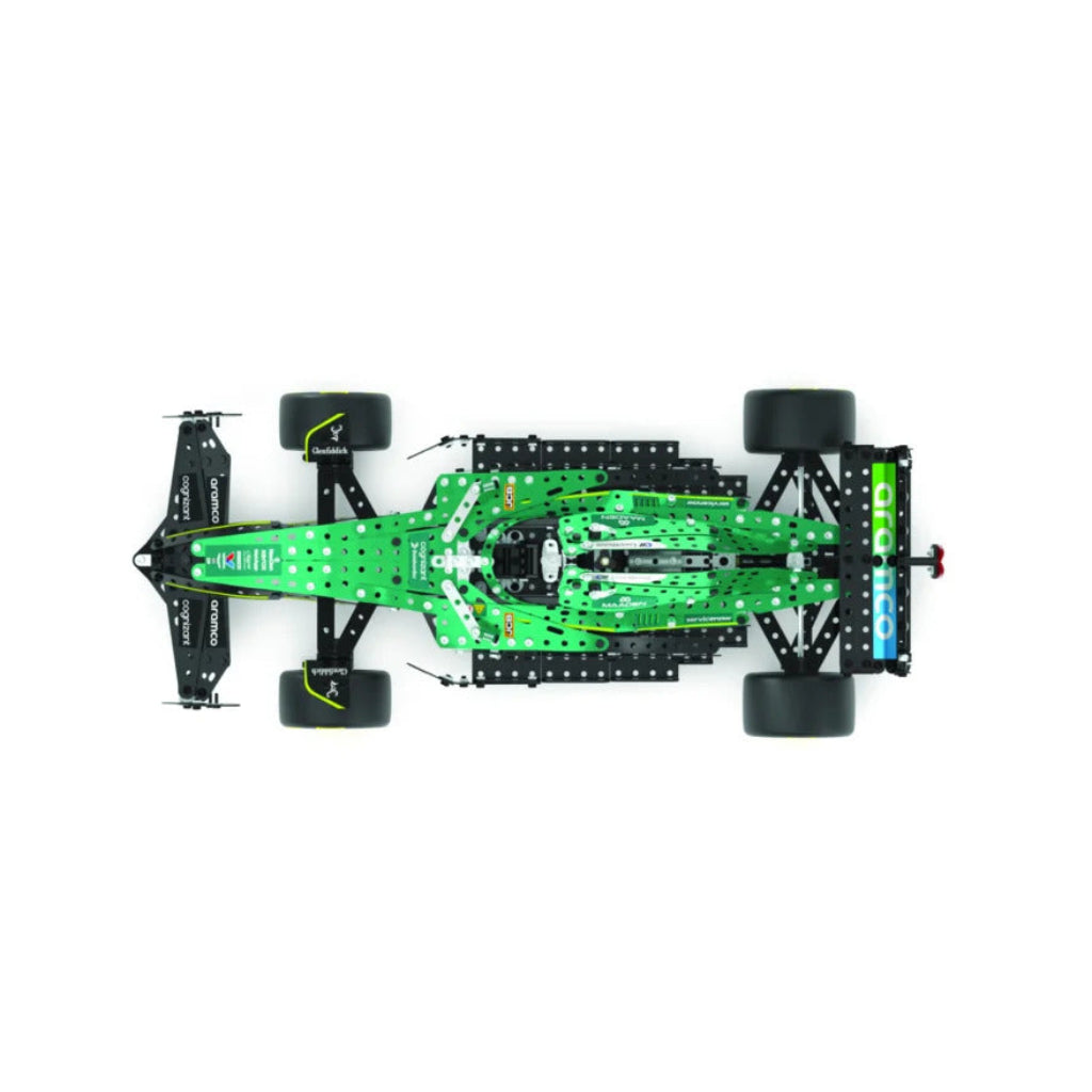 A top-down view of a green and black remote control toy race car chassis with four wheels, shown on a solid white background.