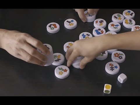 Children playing Clack! magnetic matching game with colourful magnetic discs and dice in a fast-paced family game