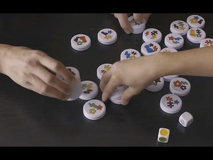 Children playing Clack! magnetic matching game with colourful magnetic discs and dice in a fast-paced family game