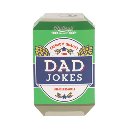 Ridley's Games 'Dad Jokes' card deck in its original green and navy blue packaging, featuring a retro beer-can-inspired design with gold wheat ears and white lettering.