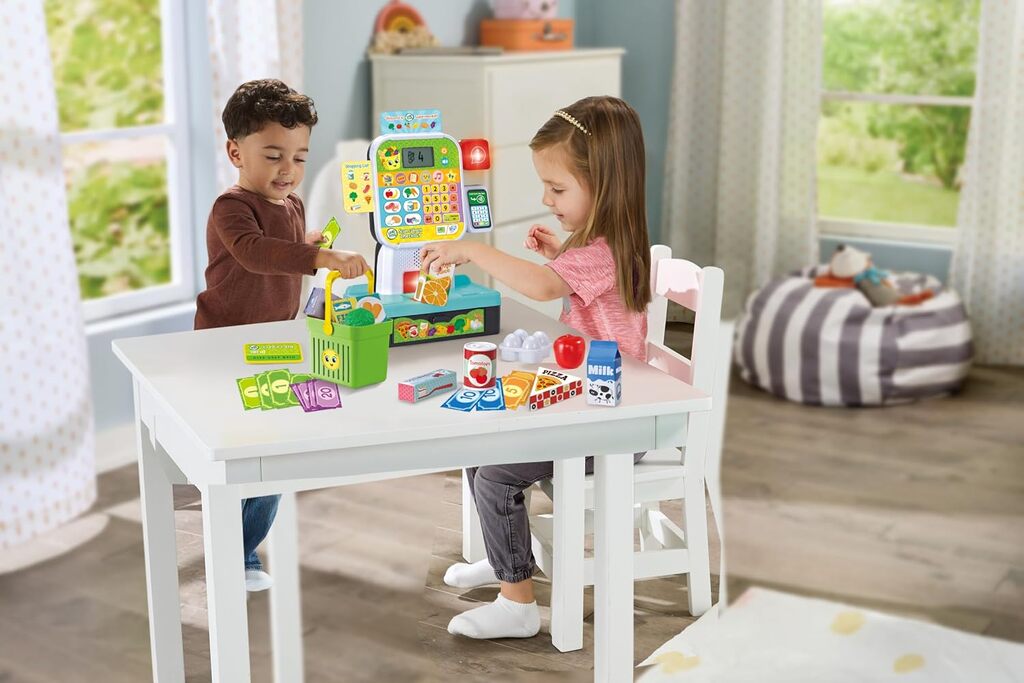 Toddler scanning a play grocery item at the LeapFrog Scan & Learn Checkout on a kitchen table