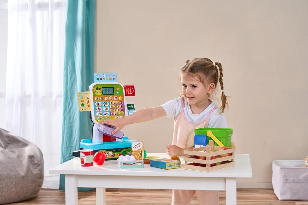 Two toddlers playing shop together at the LeapFrog Scan and Learn Checkout with play groceries