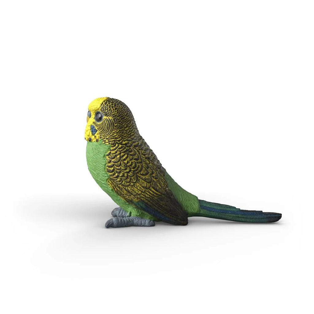Schleich budgie figure held in a child's hand to show its small and realistic modelled scale