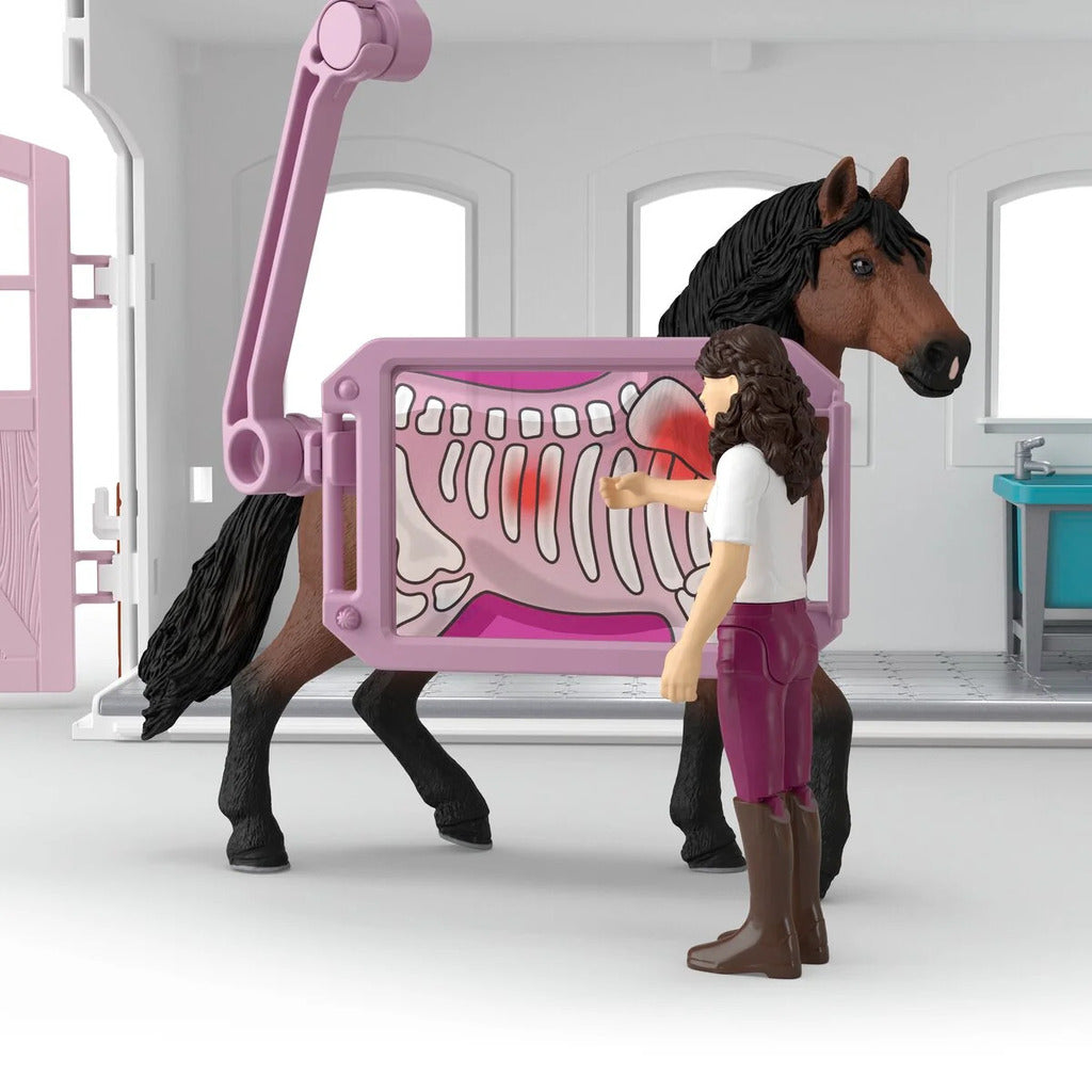 Child moving a horse figure into the Happy Horse Hospital for treatment during play