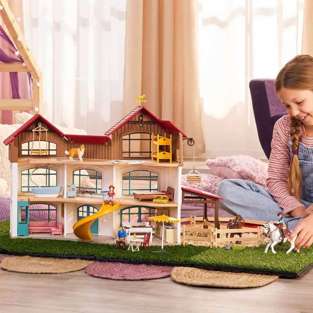 Child moving Horse Club figures between the villa and the paddock during extended play