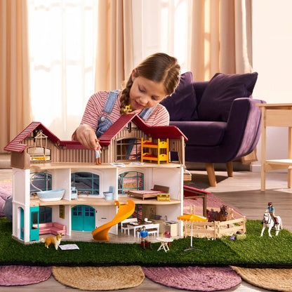 Child playing with the Schleich Lakeside Villa horse playset and paddock on a living room floor
