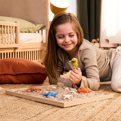 Child arranging the Schleich sea animal figures into an ocean scene on a blue play mat