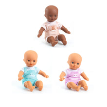 Three soft-bodied baby dolls in pink, blue and beige outfits sitting together on a white background.