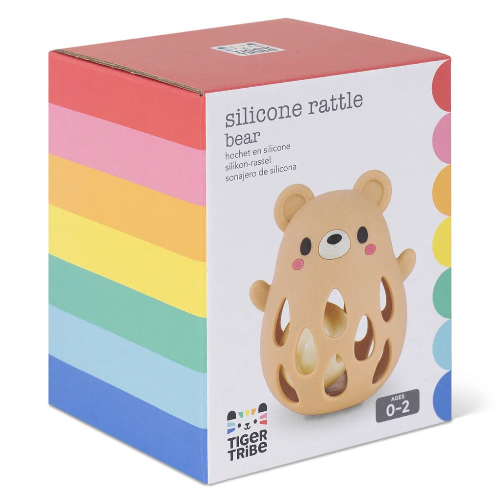 Baby holding the silicone bear rattle in one hand, showing its size against small fingers