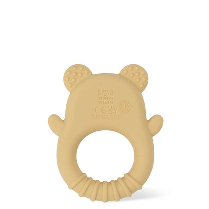 Side profile of the beige silicone teether ring showing its slim, lightweight one-piece shape