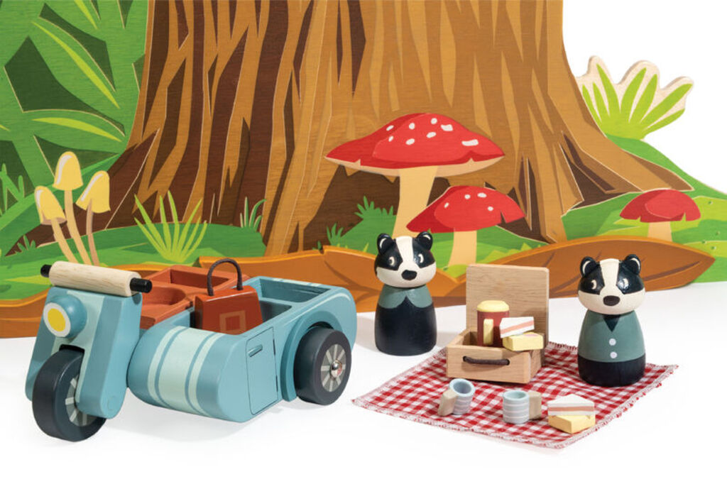 The picnic laid out on the blanket with sandwiches, Battenberg cake, cups and flask