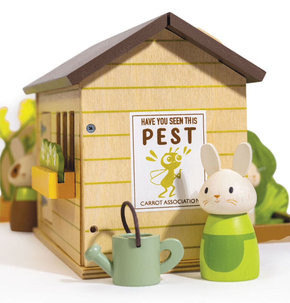 the wooden cabbage bed and watering can arranged beside the bunnies' garden shed